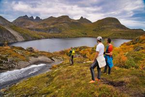 a group of people standing on a hill overlooking a lake at Lofoten Planet BaseCamp in Sørvågen