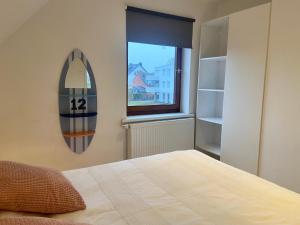 a bedroom with a surfboard on the wall next to a bed at Deichtraum - 1020 in Dahme