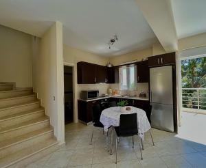 a kitchen with a table and a kitchen with a staircase at Dionysis Villas in Skala