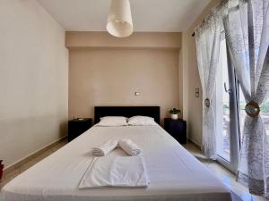 a bedroom with a large bed with two towels on it at Dionysis Villas in Skala