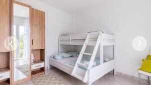 a white bunk bed in a room with a mirror at Secluded house with seawater pool in Milna +49 photos