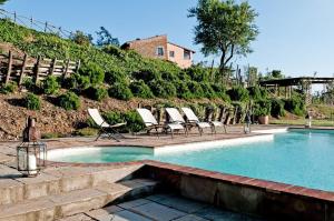 una piscina con sedie a sdraio accanto a una collina di Villa Sun And Sun 2 Pools a Montelupo Fiorentino