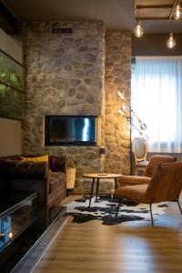 a living room with a fireplace and a stone wall at Lake Hotel La Pieve in Pisogne