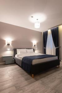 a bedroom with a large bed with a blue blanket at Omnia Apartments in Iaşi