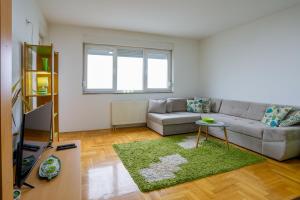 een woonkamer met een bank en een tafel bij Apartman Green in Lukavica