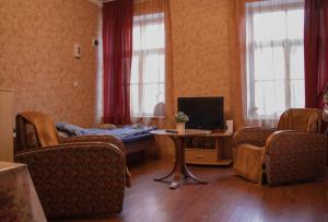 een woonkamer met een bank en een tv bij KurBrauksim Goldingen Apartments in Kuldīga