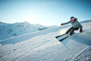 a person is skiing down a snow covered slope at Kesselspitze Hotel & Chalet, Valamar Collection - 4 Star Superior in Obertauern