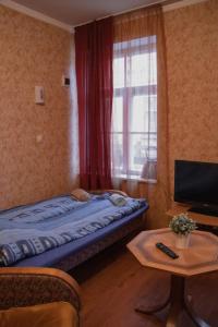 een kleine kamer met een bed en een raam bij KurBrauksim Goldingen Apartments in Kuldīga