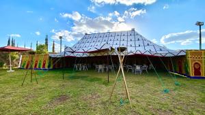a circus tent with tables and chairs in a field at Palais Benfatah in Marrakesh