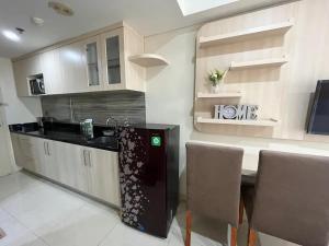 a kitchen with a sink and a table with chairs at Louis Kienne Simpang Lima in Semarang