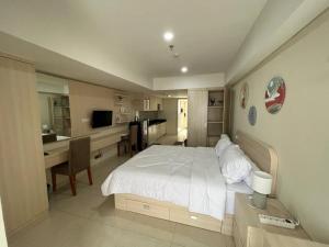 1 dormitorio con 1 cama blanca grande y escritorio en Louis Kienne Simpang Lima en Semarang