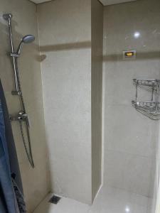 La salle de bains est pourvue d'une douche et d'une porte en verre. dans l'établissement Louis Kienne Simpang Lima, à Semarang