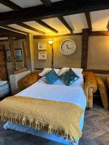 a bedroom with a large bed with a clock on the wall at Arms Cottage in Bridge