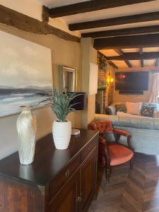 a living room with a table with a vase on it at Arms Cottage in Bridge