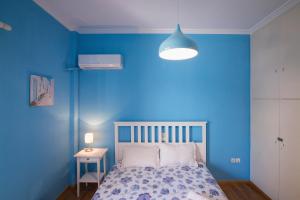 a blue bedroom with a bed and a blue wall at Blue House in Athens