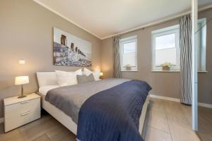 a bedroom with a large bed and two windows at Ferienwohnung Boddenblick in Puddemin