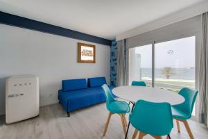 a living room with a blue couch and a table and chairs at Apartamentos La Kiki in San Antonio Bay