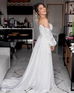 Una mujer con un vestido blanco parada en una sala de estar en lasuita-exclusive suites ceserea-luxury suite, en Cesarea