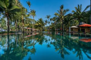 - une piscine avec des palmiers et des parasols dans l'établissement Sunova Pool Villa - Koh Chang, à Ko Chang