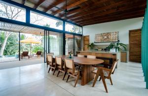 una cucina e una sala da pranzo con tavolo e sedie in legno di Villa Alba - Ahangama ad Ahangama