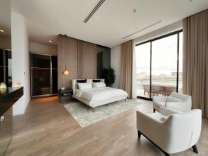 a bedroom with a bed and a couch and chairs at Villa 72 RAK in Ras al Khaimah