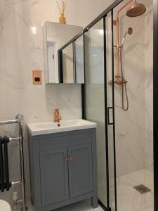 a bathroom with a sink and a shower at Lavish The Marble Apartment in Bury Saint Edmunds