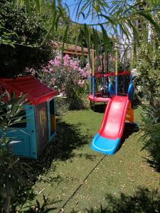 a playground with a slide in a garden at Katerina Apartments in Kalymnos