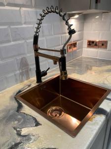 a kitchen counter with a sink with austed at Lavish The Marble Apartment in Bury Saint Edmunds