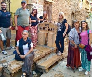 un gruppo di persone in piedi accanto a un cartello stradale di Hotel Shahi Garh a Jaisalmer