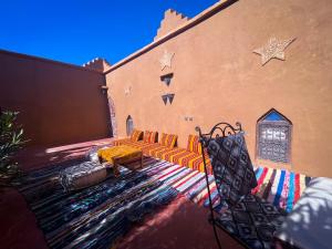 un grupo de sillas y una alfombra frente a un edificio en Dar Yaya, en Mhamid