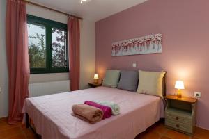 a bedroom with a large white bed with two lamps at Koxyli Studios & Apartments in Kaligata