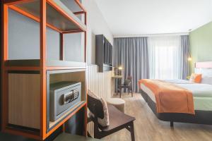 Habitación de hotel con cama y TV en the niu Amity en Potsdam