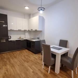 a kitchen with a table and chairs in a room at Bečići WOW Apartment 20 in Rafailovici