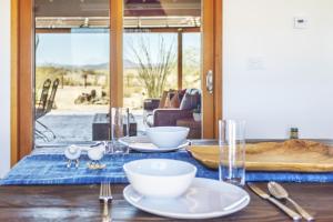 una mesa con platos y cuencos encima en Constellation Compound - Your Own PRIVATE 10 Acres home, en Joshua Tree