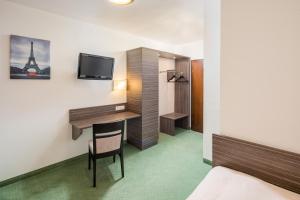 a hotel room with a desk and a tv at Hotel zur Post in Hemmingen