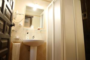 a bathroom with a sink and a mirror at Hostal Rocio in Sanlúcar la Mayor