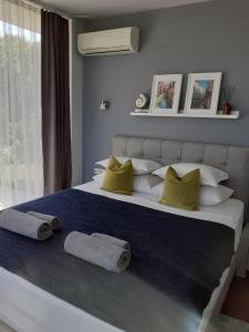 a bedroom with a large bed with two towels on it at Zlaten Briz Villa in Osenovo