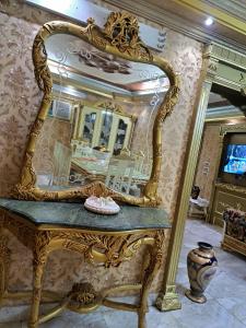 einen großen goldenen Spiegel auf einem Tisch in einem Zimmer in der Unterkunft Hijaz Street Hotel in Kairo