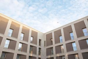 a facade of a building with the sky in the background at the niu Amity in Potsdam