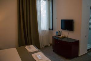 ein Hotelzimmer mit einem Bett und einem Fernseher in der Unterkunft Zhebota garden Tianeti in Zhebota