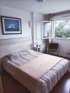 una camera con un letto e una sedia e una finestra di Superbe appartement avec piscine chauffée et parking privé - La Clé Chaumoise a La Rudelière