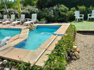 een klein zwembad met stoelen en een zwembad bij Le clos des cigales les lauriers roses in Le Thoronet