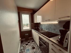 een kleine keuken met een wastafel en een raam bij Le Miramar, face mer et standing in Saint-Jean-de-Monts +6 foto's