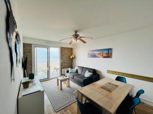 een woonkamer met een tafel en een bank bij Le Miramar, face mer et standing in Saint-Jean-de-Monts