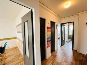 um corredor com portas em preto e branco e pisos de madeira em Le Miramar, face mer et standing em Saint-Jean-de-Monts