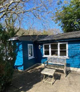 uma casa azul com um banco à frente em Somerset Lodge, a secret hideaway em Bath