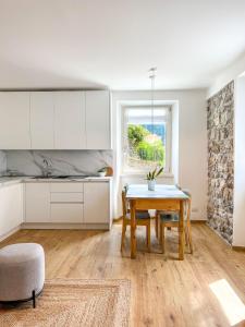 テンノにあるSant'Antòni Apartmentsの白いキャビネット、テーブル、テーブル付きのキッチンが備わります。