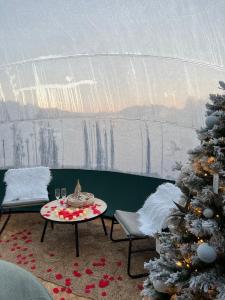 una sala de estar con un árbol de Navidad y una mesa en Bulle Time Flies - logement insolite en Bouillon