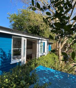 a blue house with a tree in front of it at Somerset Lodge, a secret hideaway in Bath