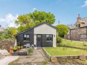 a small black and white house with a yard at Cosy cottage near Hartland Village in Bideford